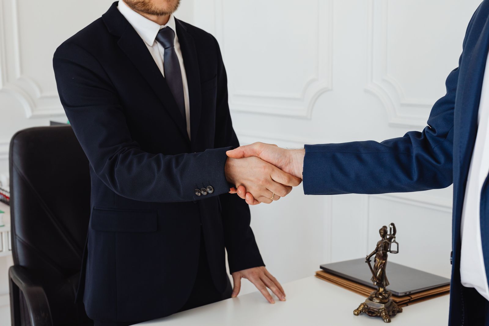 Apretón de manos entre dos abogados de traje